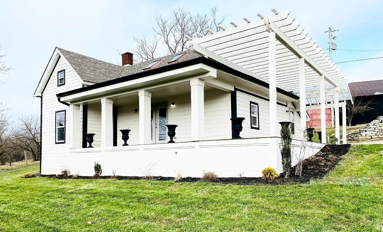 A white house with black trim and a porch.